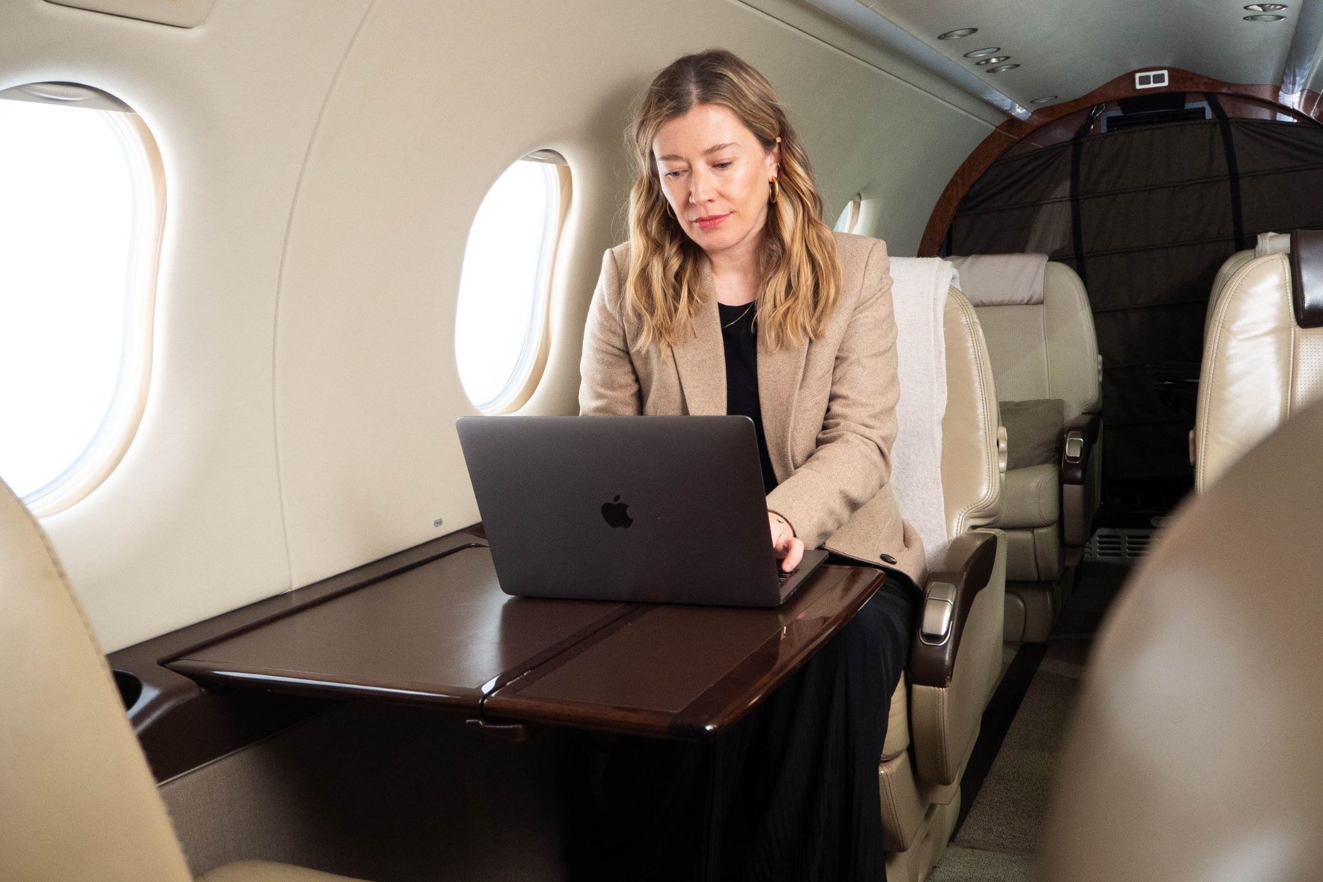 Pilatus PC‑12 cabin: passenger working at the laptop workstation