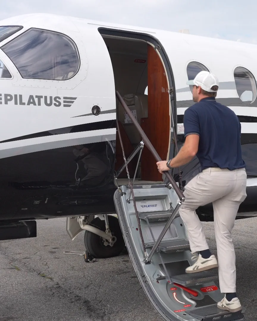 A NectAir guest climbing the air‑stair of our Pilatus PC‑12